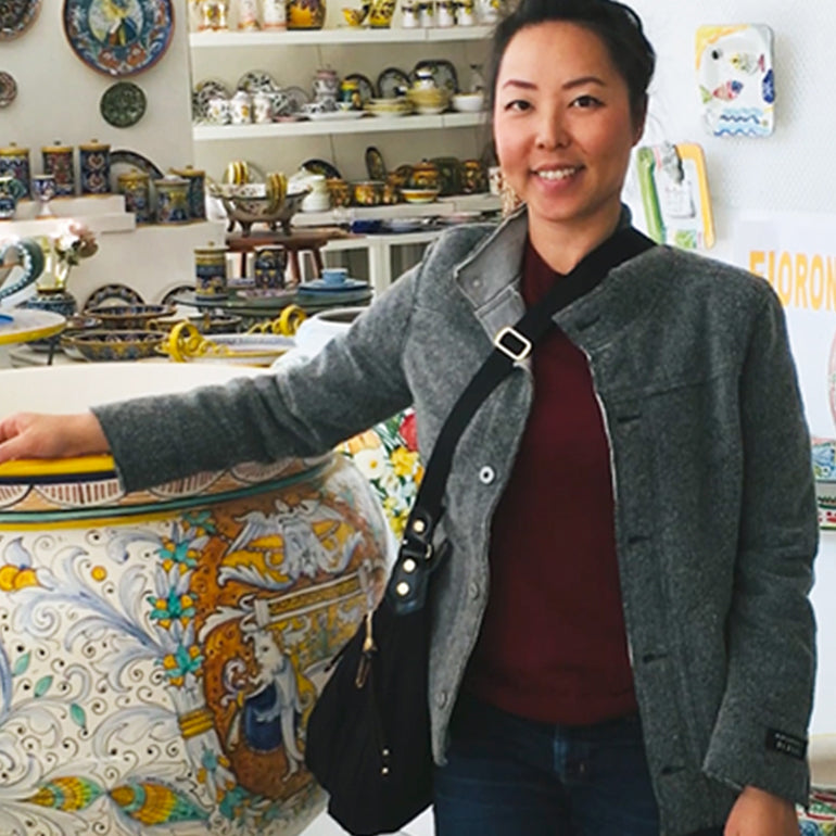 Designer Catherine standing in front of pottery