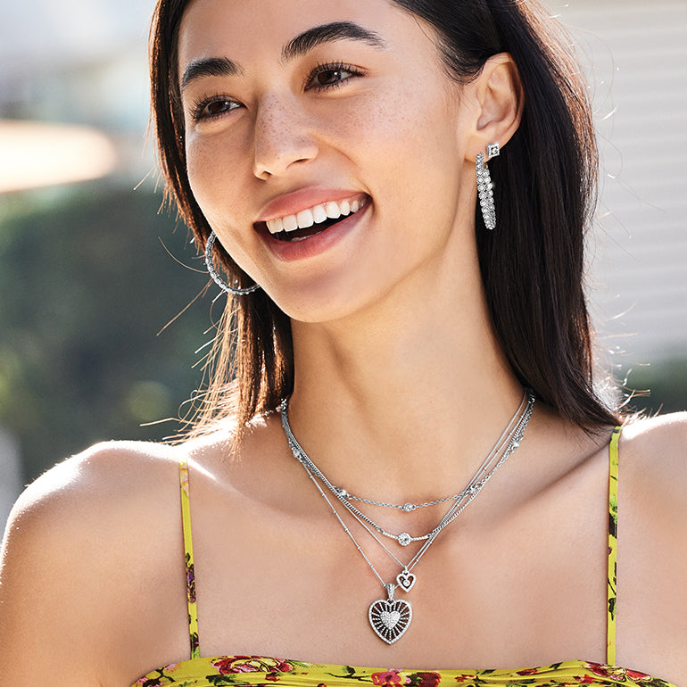 Model wearing multiple sparkle Illumina necklaces layered