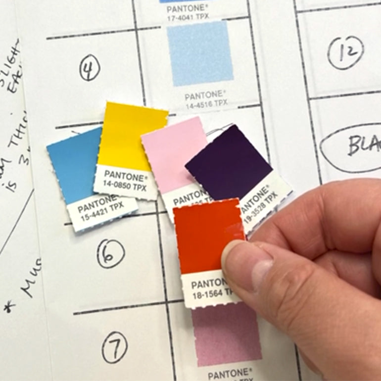 A hand holding a Pantone color swatch