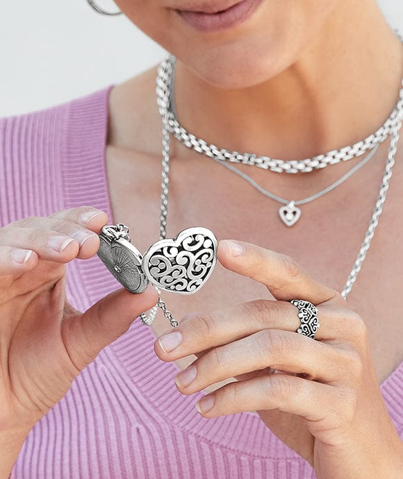 A model looking at an open locket