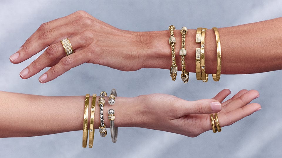 Two models wearing gold bracelets