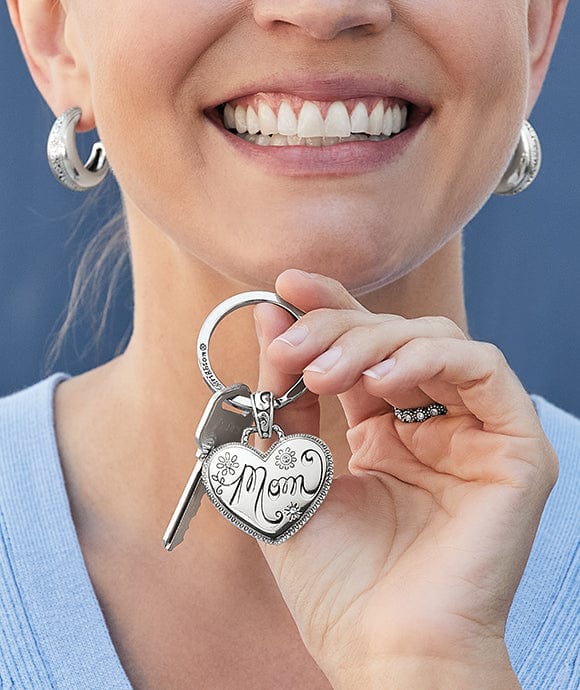 A model holding a 'Mom' key fob