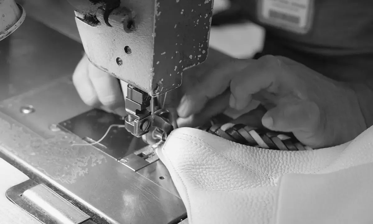 Close-up of a sewing machine sewing a leather handbag