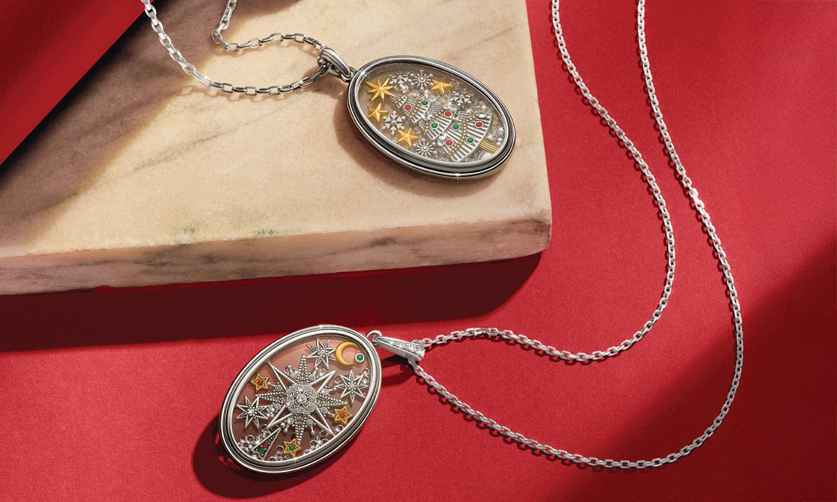 Silver necklace with intricate pendant on a red surface