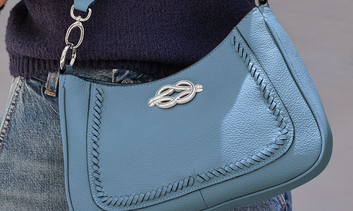 Blue Brighton leather handbag with a silver accent piece worn by a model