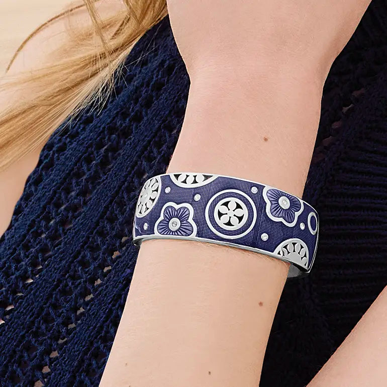 Navy blue patterned Brighton cuff bracelet on a person's wrist with a dark background