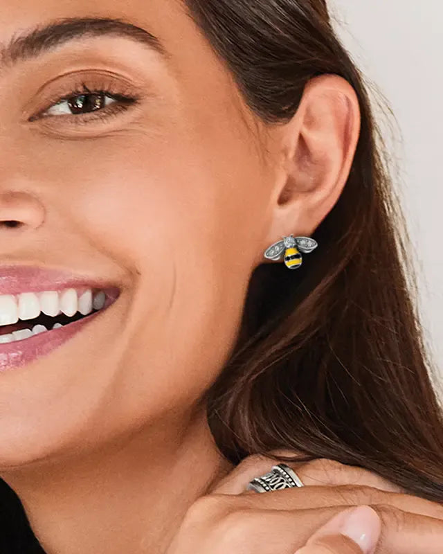Close-up of a woman wearing Brighton bee earrings with a white background