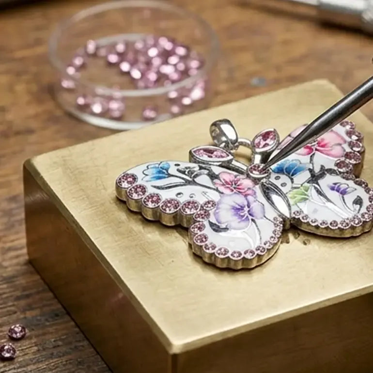 Butterfly-shaped Brighton jewelry pendant with pink gemstones on a wooden surface