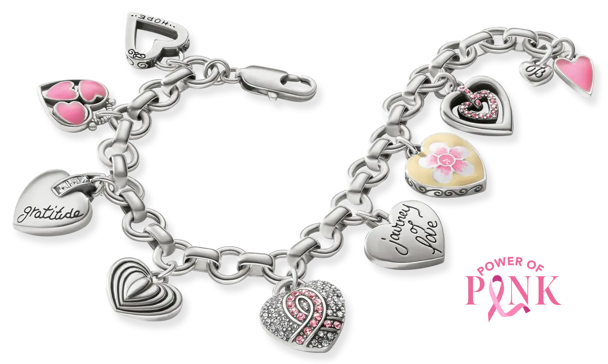 A silver-tone charm bracelet featuring multiple heart-shaped charms, including engraved names, a pink-and-white floral charm, and a heart with a pink ribbon design, shown on a white background.