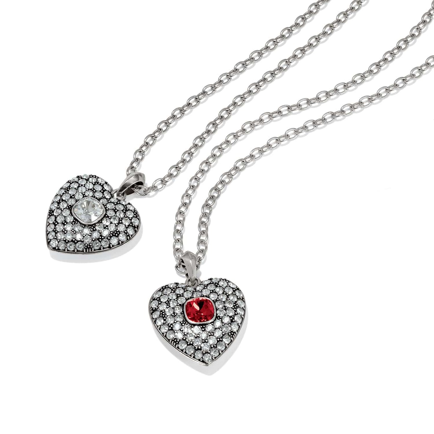 Brighton pendant necklaces with silver-plated heart charms featuring crystal pavé and clear and red center stones on a white background