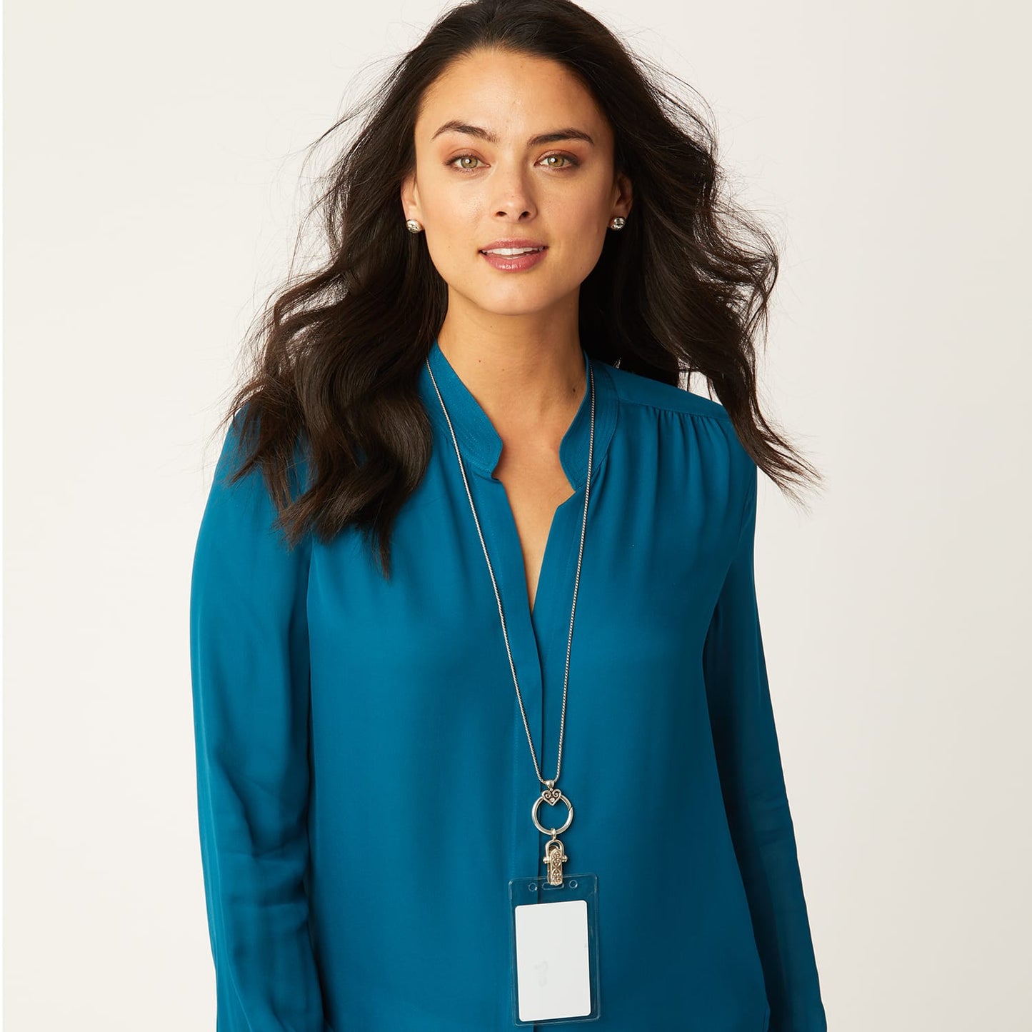 Model wearing a Brighton long silver-plated chain necklace with scrolled ring pendant and clip-on ID badge holder