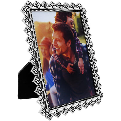 Brighton picture frame with silver-plated ornate scrollwork border and crystal accents surrounding a family photo on a white background