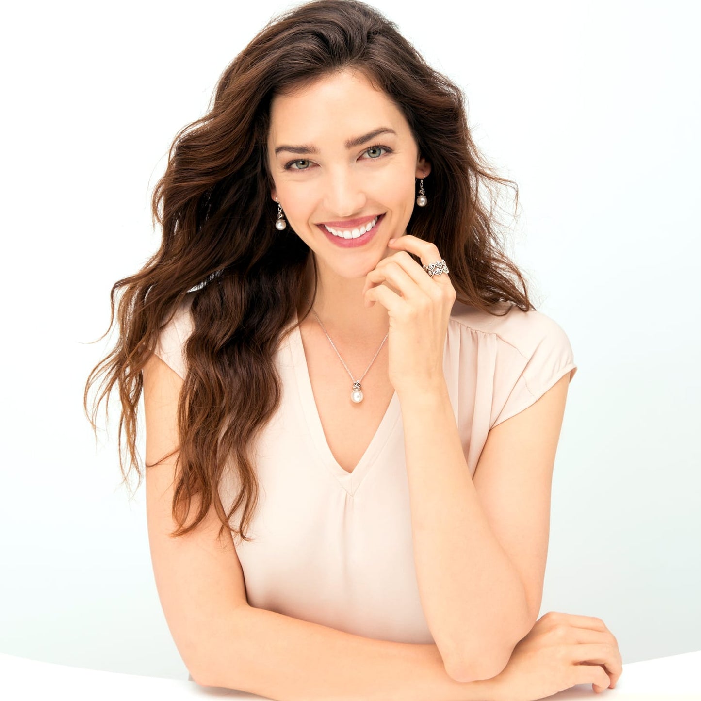 Model wearing a Brighton silver-plated pearl pendant necklace with coordinating pearl drop earrings and heart ring