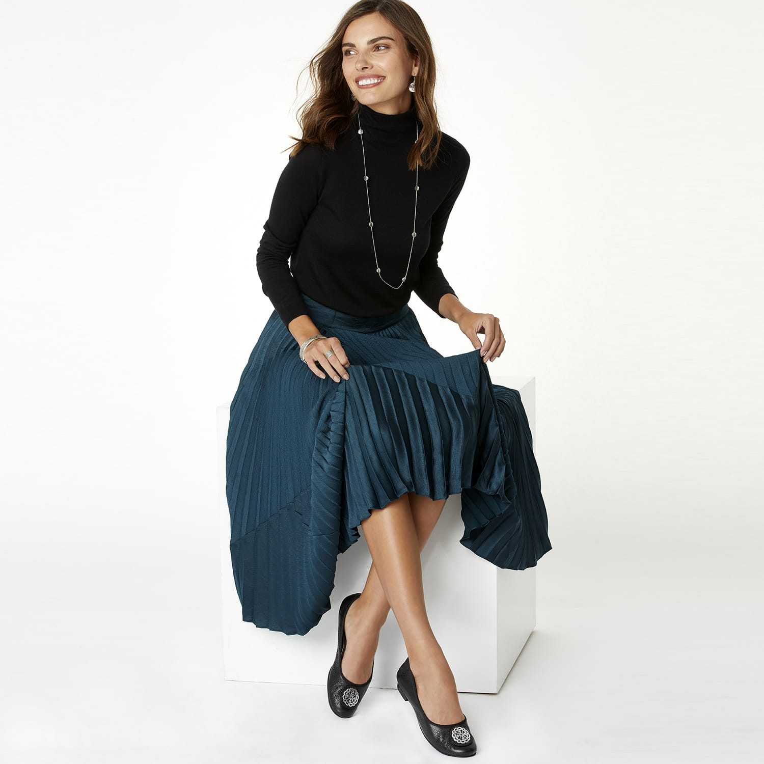 Model wearing a Brighton long silver-tone station necklace with round beaded accents over a black turtleneck