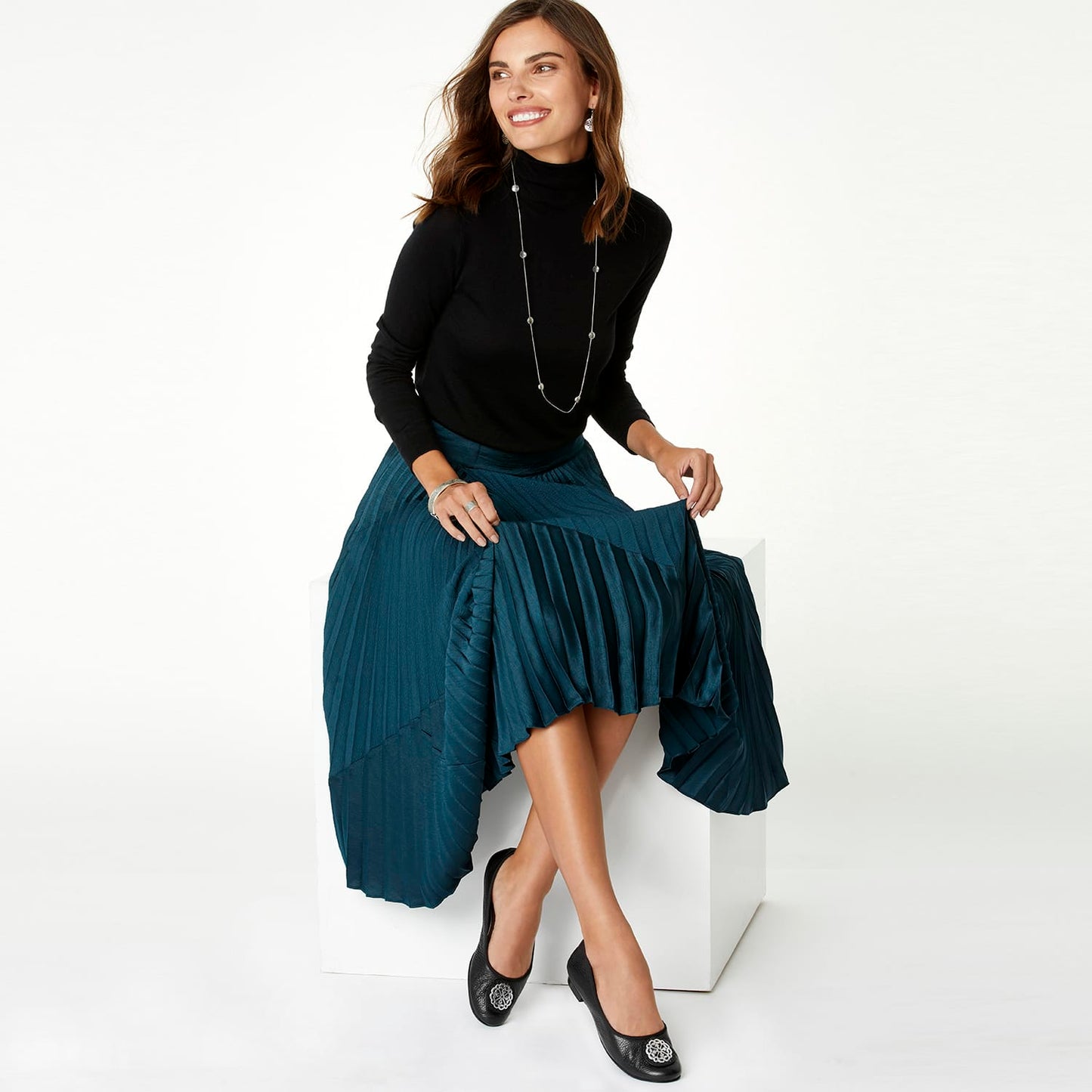 Model wearing a Brighton long silver-tone station necklace with round beaded accents over a black turtleneck