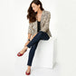 Model wearing Brighton red leather ballet flats with silver-tone medallion accents, paired with dark jeans and leopard blazer