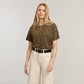 Model wearing a Brighton black leather belt with gold-tone buckle, styled with leopard print top and cream jeans