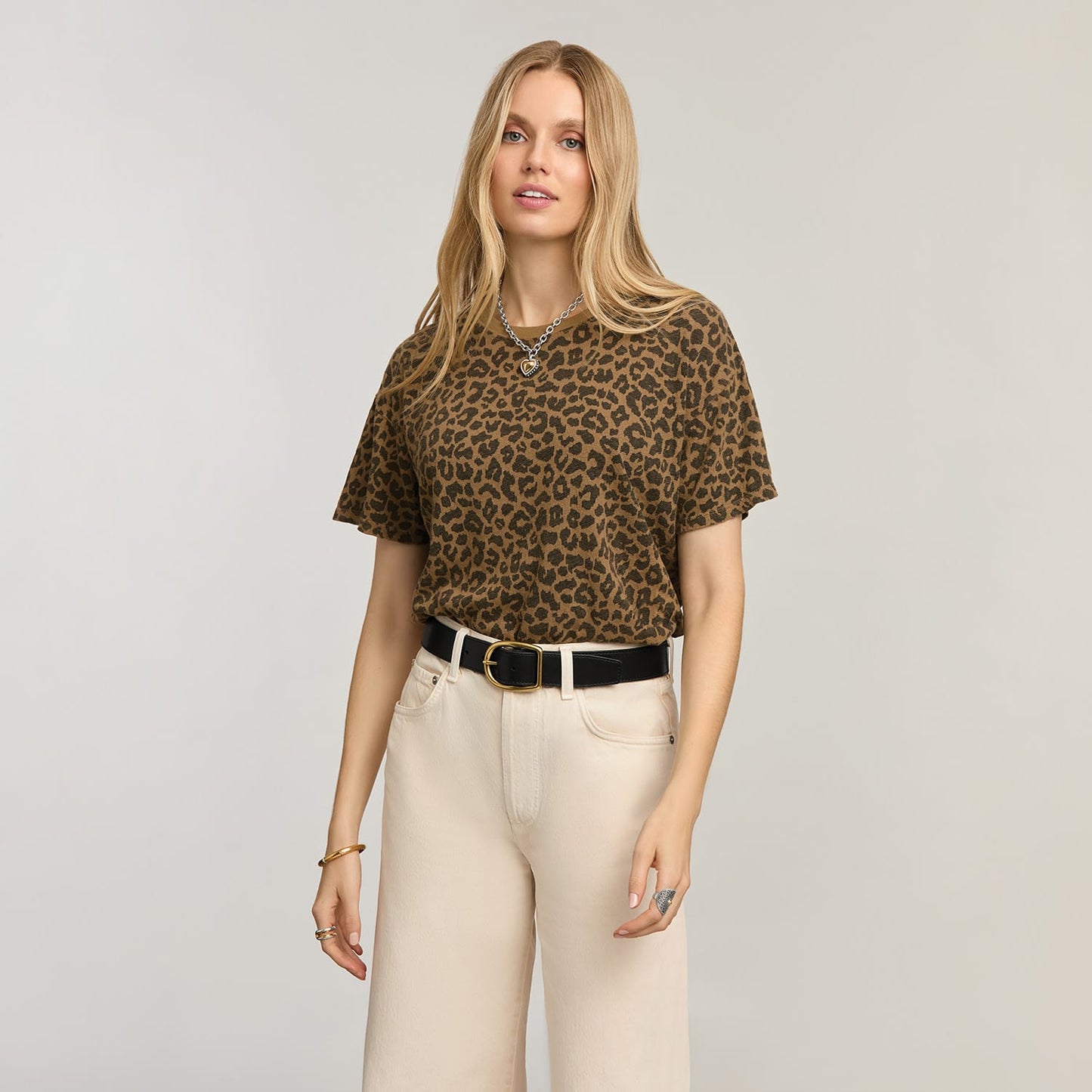Model wearing a Brighton black leather belt with gold-tone buckle, styled with leopard print top and cream jeans