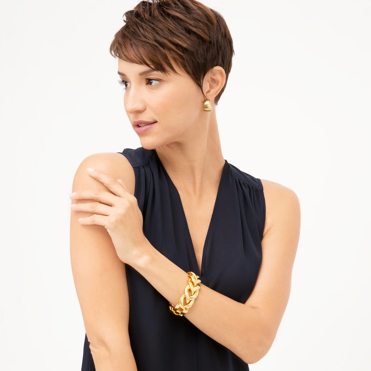Model wearing Brighton gold-tone drop earrings paired with a chunky gold-tone woven link bracelet