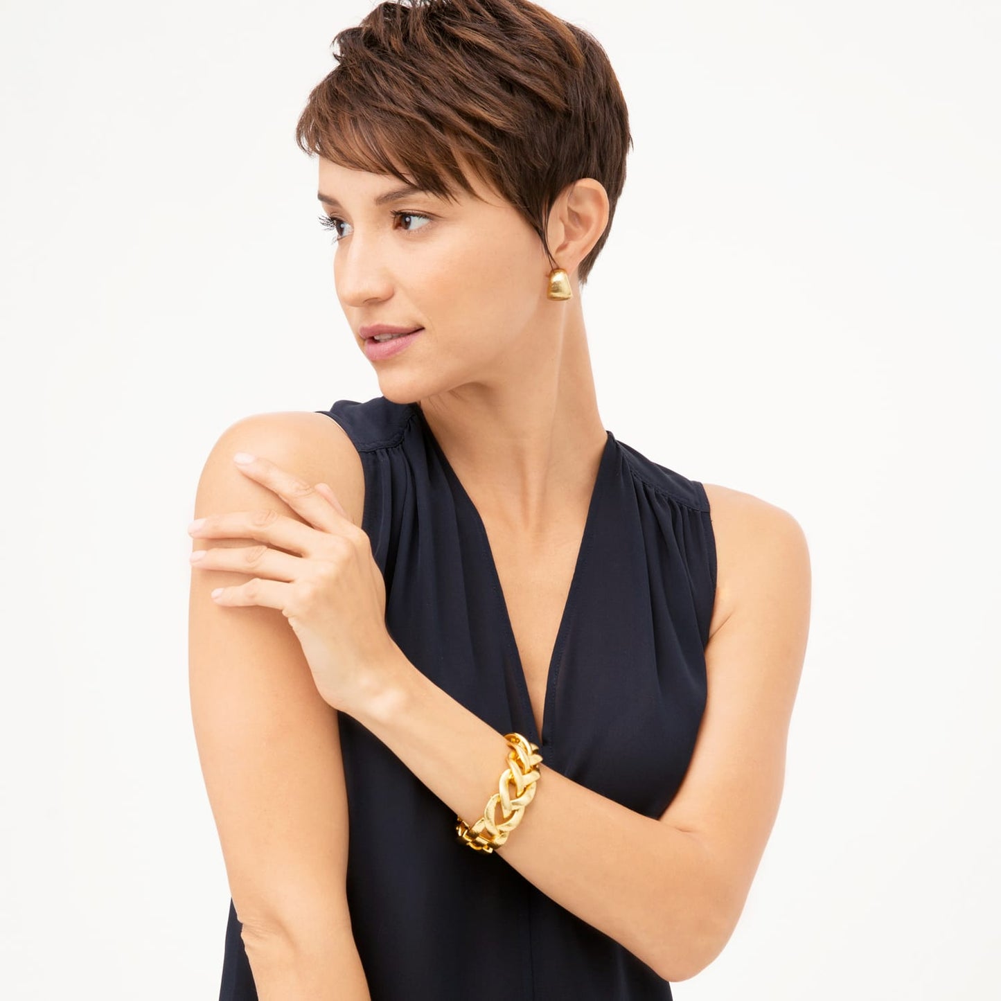Model wearing Brighton gold-tone drop earrings paired with a chunky gold-tone woven link bracelet