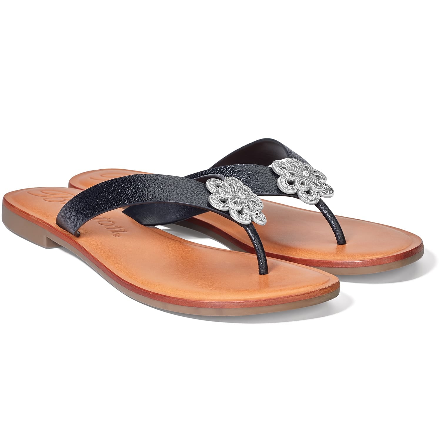 Brighton thong sandals with black textured straps, silver-tone floral medallions, and tan leather footbeds on a white background