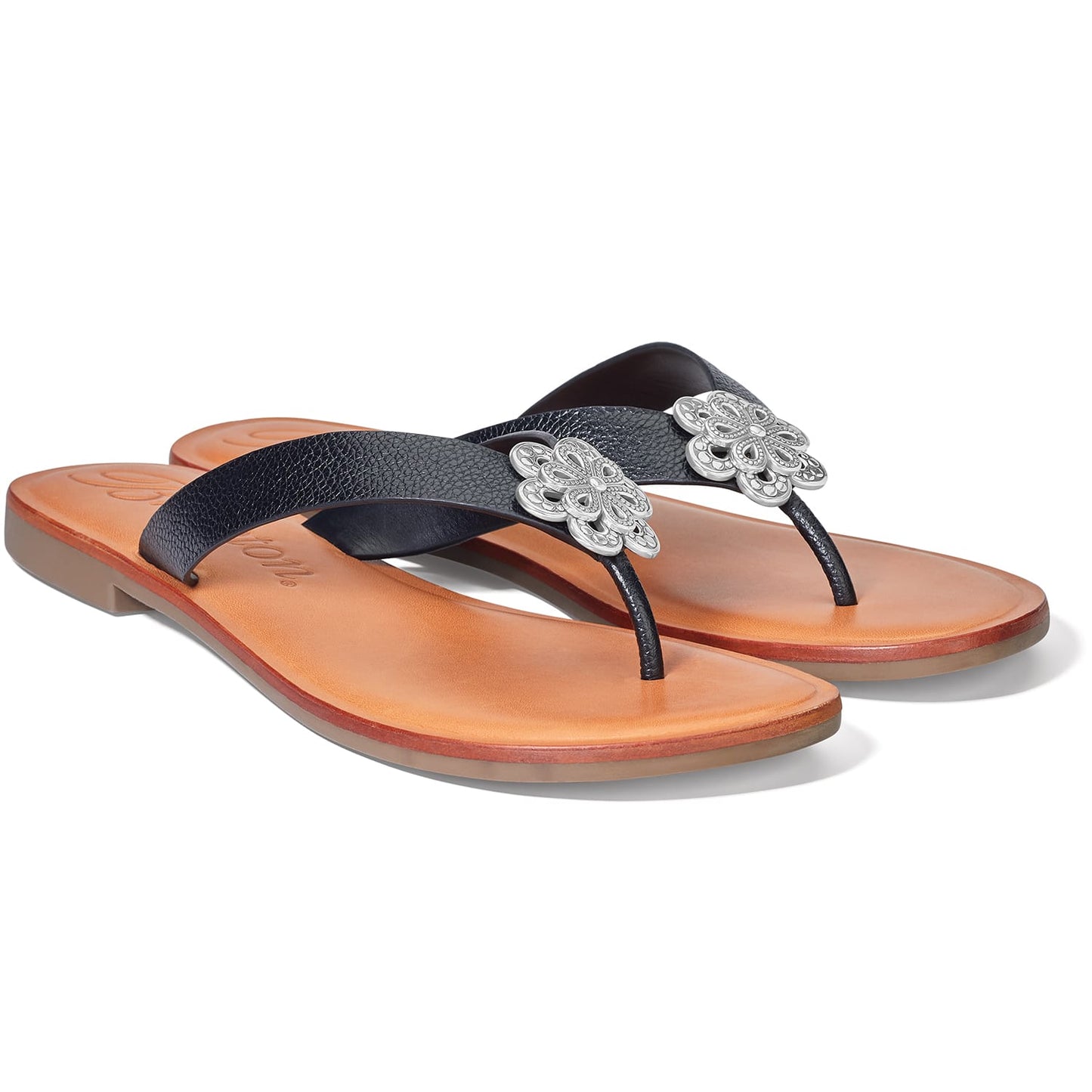 Brighton thong sandals with black textured straps, silver-tone floral medallions, and tan leather footbeds on a white background