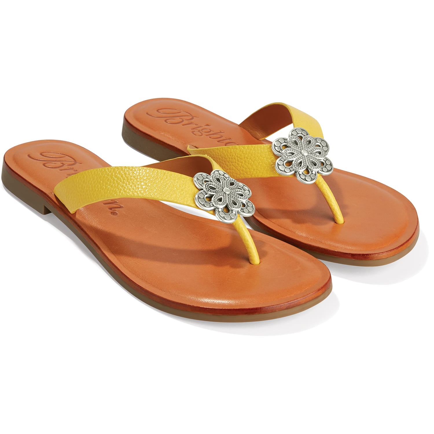 Brighton yellow thong sandals with silver-tone floral medallion accents and tan leather footbeds on a white background