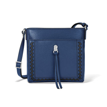 Brighton blue leather crossbody handbag with black zigzag stitching, silver-tone knot accent, and leather tassel on a white background