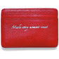 Brighton red pebbled leather card case with silver embossed script reading Make every moment count on a white background