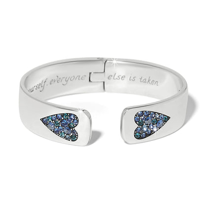 Brighton hinged cuff bracelet with silver-plated finish and blue crystal heart accents at open ends on a white background