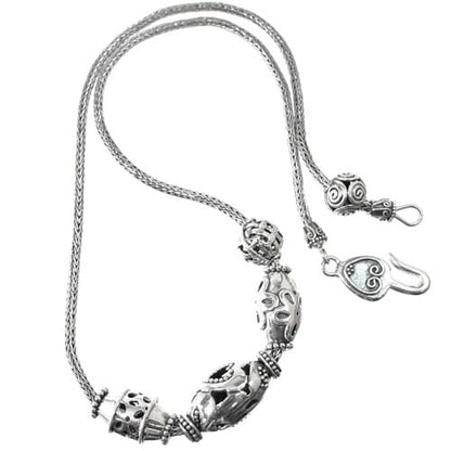 Brighton necklace with sterling silver ornate oval beads, braided chain, and hook clasp on a white background