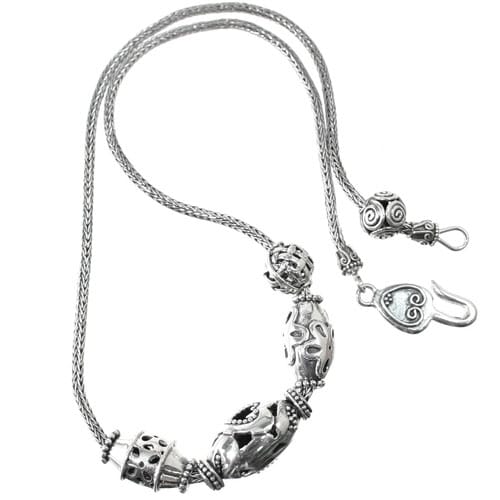 Brighton necklace with sterling silver ornate oval beads, braided chain, and hook clasp on a white background
