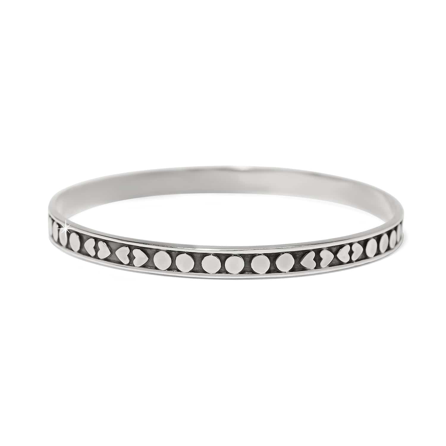 Brighton bangle bracelet in sterling silver with heart and dot patterned band design on a white background