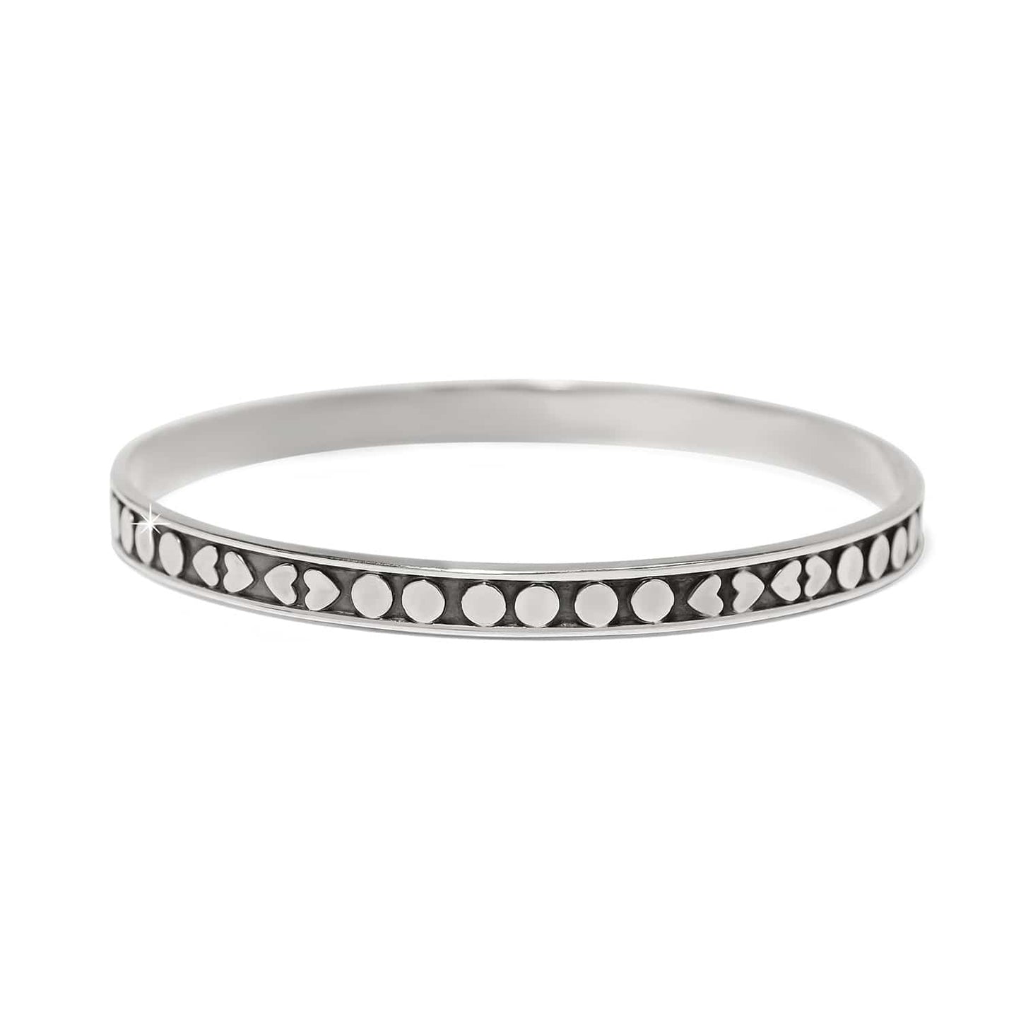 Brighton bangle bracelet in sterling silver with heart and dot patterned band design on a white background