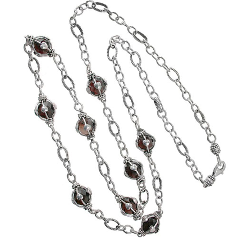 Brighton long chain necklace with wire-wrapped deep red faceted stones and sterling silver links on a white background