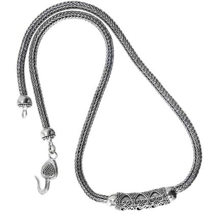 Brighton necklace with sterling silver braided chain, ornate scrollwork centerpiece, and hook clasp on a white background