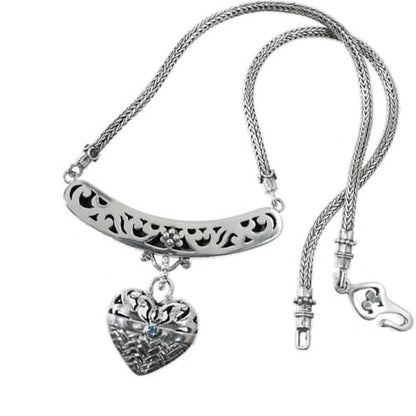 Brighton necklace with sterling silver filigree bar, heart pendant, blue crystal accent, and rope chain on a white background