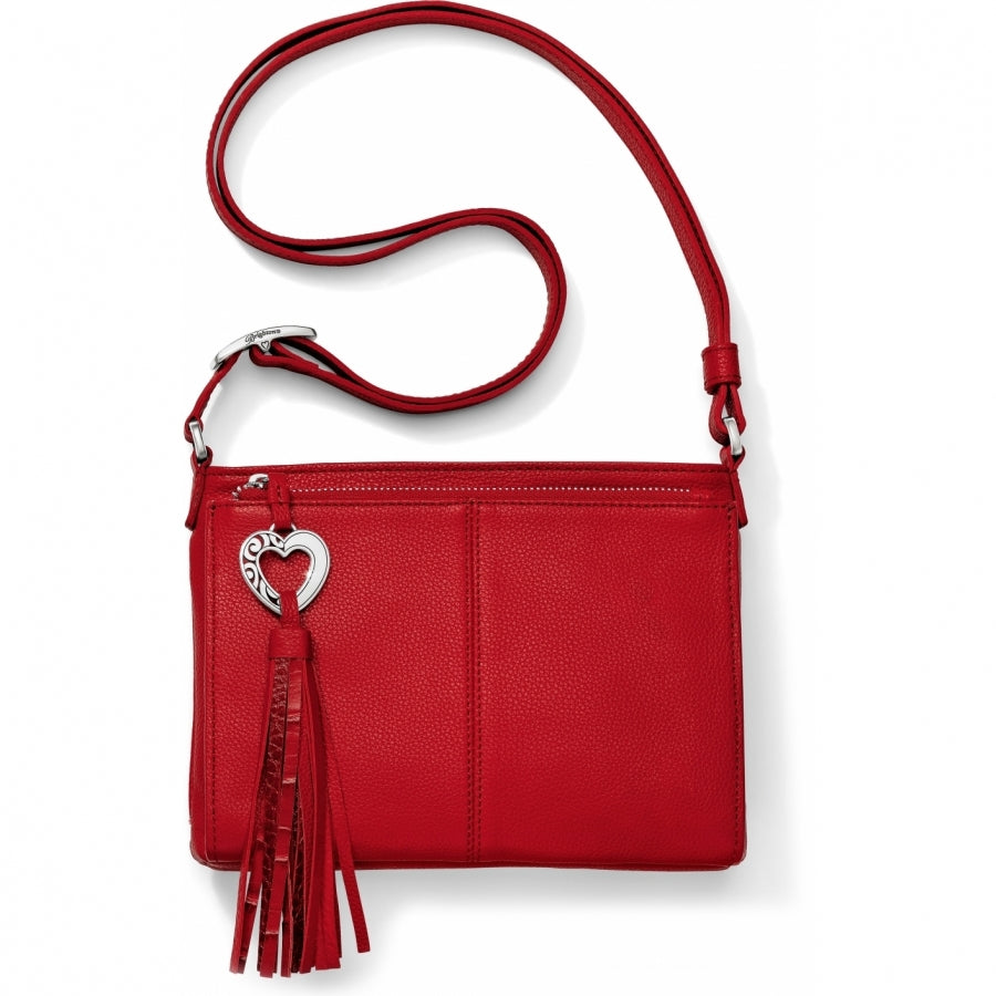 Brighton crossbody handbag in red leather with silver-tone heart charm and tassel accent on a white background