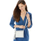Model with a Brighton white crossbody handbag featuring silver-tone heart accent and tassel detail
