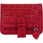 Brighton red croc-embossed leather wallet with heart accent, tab closure, and zippered pocket on a white background