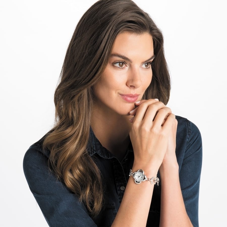 Model wearing a Brighton silver-tone watch with round dial and beaded charm bracelet band