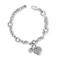 Brighton charm bracelet with silver-plated link chain, filigree heart charm, and engraved round charm on a white background