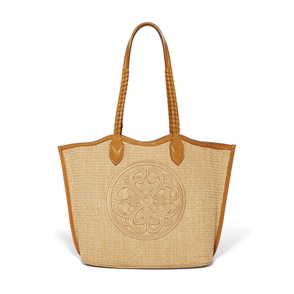 Brighton straw tote handbag with tan leather trim, braided handles, and embroidered medallion design on a white background