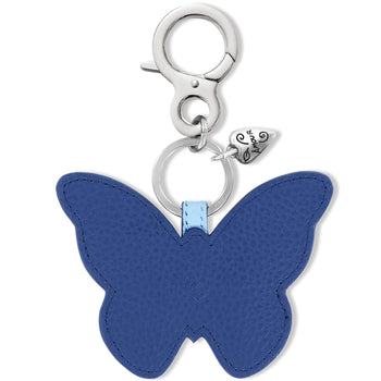 Brighton butterfly bag charm in blue leather with silver-tone clasp and heart accent on a white background