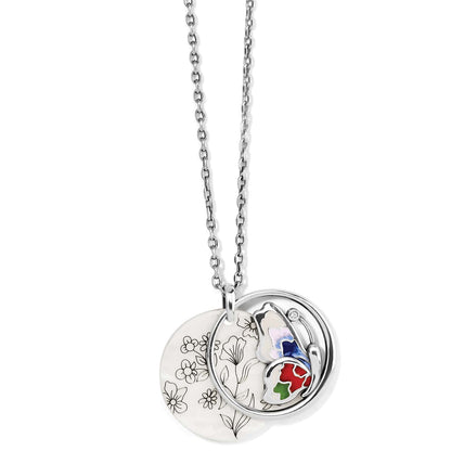 Brighton pendant necklace with floral etched disc and silver-plated enamel butterfly charm with crystal accent on a white background