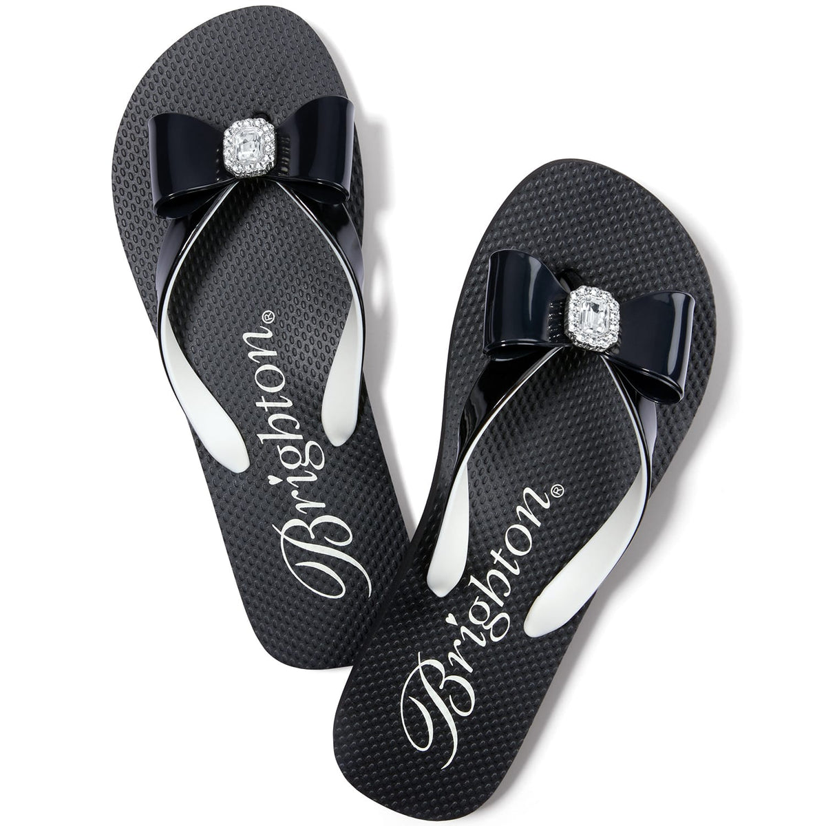Brighton black rubber flip-flop sandals with glossy bow accents and crystal square centerpieces on a white background
