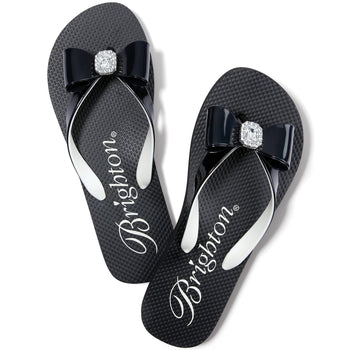 Brighton black rubber flip-flop sandals with glossy bow accents and crystal square centerpieces on a white background