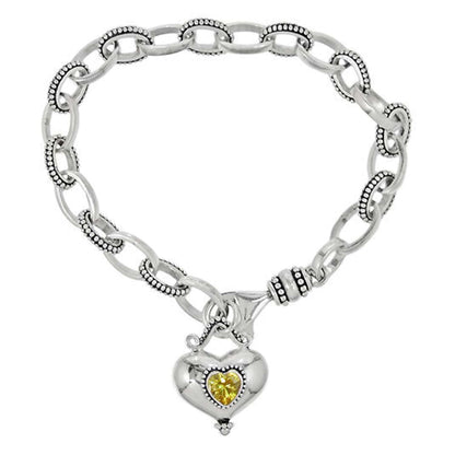 Brighton charm bracelet with sterling silver oval links and heart pendant featuring yellow crystal on a white background