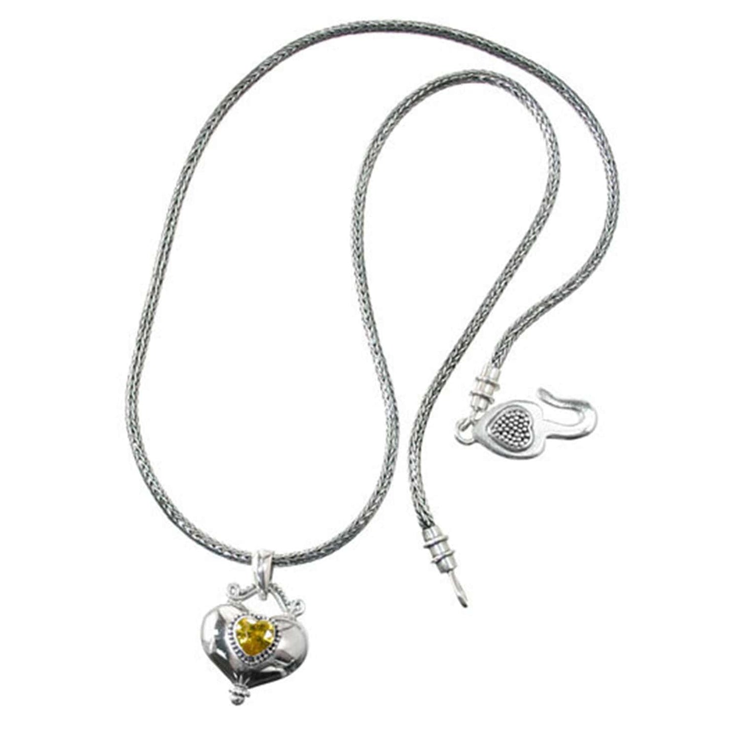 Brighton pendant necklace with sterling silver chain, heart pendant, and yellow crystal accent on a white background