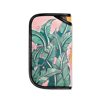 Brighton eyeglass case with tropical green banana leaf print on pink background and black leather trim on a white background